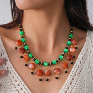 Detail of bohemian ethnic choker with colorful resin beads and tassels on white lace top