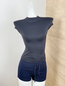 Detail of slim-fit black top with padded shoulders and high-stretch seamless fabric