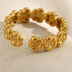 Close-up of 18K gold plated flower ring showing detailed petal design on stone surface
