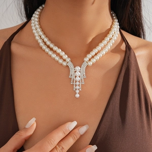 Detail of elegant double-layered pearl necklace with rhinestone pendant on a model