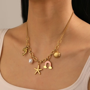 Detail of gold-plated necklace with dolphin, star, pearl, shell and rainbow charms on model
