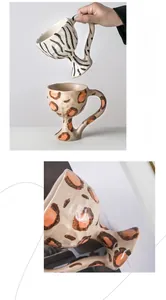 Detail of handmade ceramic goblets with zebra and leopard prints on a textured matte glaze