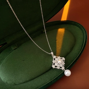 Detail view of the zircon flower pendant with pearls on a velvet jewelry box