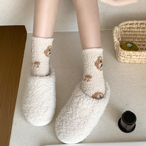 Detail of white fleece slippers paired with bear pattern socks for winter warmth