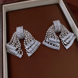 Macro view of silver fringe bow earrings with shimmering zircon crystal stones