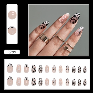 Detail view of almond press-on nails with leopard print and pink gradient heart designs
