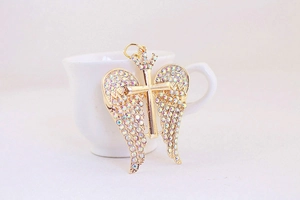 Close-up of golden angel wing cross keychain with crown detail and colorful rhinestones