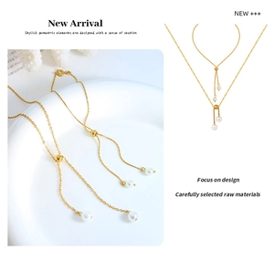 Detail of a gold adjustable Y-necklace with imitation pearl tassels on a white plate