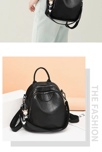 Detail of black PU leather backpack showing lychee texture and cute calf keychain