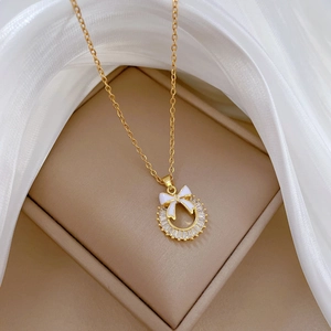 Macro detail of a gold bow and crystal ring pendant on a soft jewelry box display
