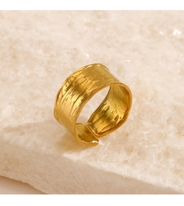 Macro shot of wide adjustable gold ring with hammered texture on a mineral stone base
