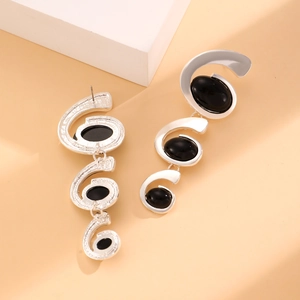 Detail shot of silver spiral earrings featuring three tiered black oval gemstone cabochons