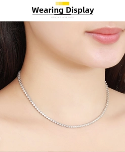 Detail of a 2mm moissanite tennis necklace in sterling silver worn by a female model