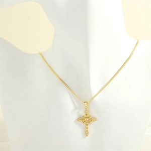 Detail of cross pendant with yellow stones and white crystals on a gold chain