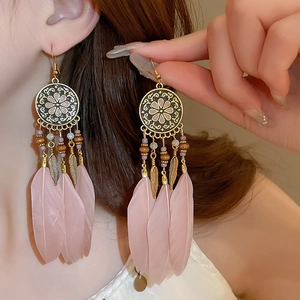 Bohemian drop earrings featuring pink feathers, vintage gold mandala charms and beads