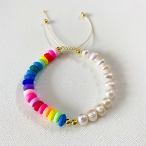 Detailed shot of rainbow polymer clay disc beads with white freshwater pearls on a bracelet