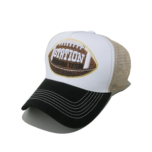 Detail of rugby embroidery on a black and white mesh trucker cap with contrast stitching