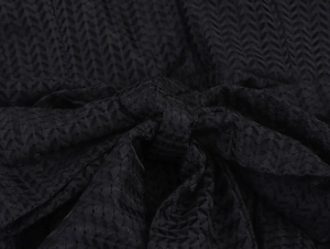 Detail of elegant black mesh fabric showing ruffled texture and bow tie waist design