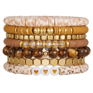 Close-up of bohemian multi-layer elastic bracelets with polymer clay and metal beads
