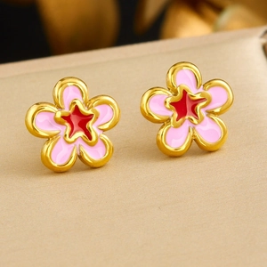 Detail of gold-plated earrings with pink enamel petals and a red star center