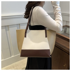 Detail of tricolor paneled tote bag shown on model for daily commuting style