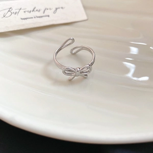 French palace style silver bow ring on white porcelain tray for everyday jewelry display