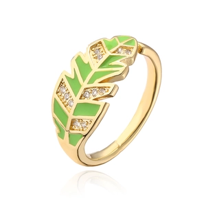 Detail of gold leaf ring featuring green enamel and sparkling zircon stone accents