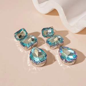 Dettaglio degli orecchini di lusso con cristalli verde acqua e pendenti a nappa