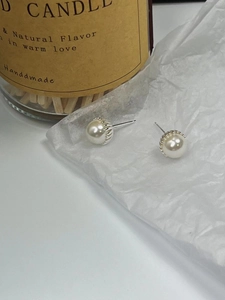 Elegant French style pearl stud earrings with silver gear base on minimalist background