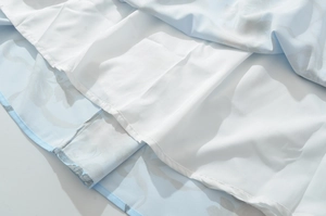 Dettaglio macro dell'abito in pizzo floreale blu con fodera bianca e cuciture fini