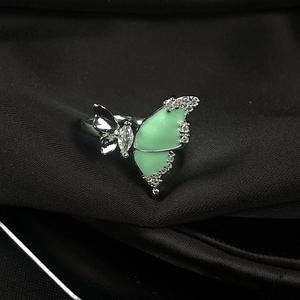 Macro shot of silver butterfly ring with light green enamel wings and cubic zirconia accents