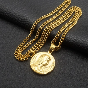 Macro detail of gold Mother Mary pendant on black background for vintage steel necklace