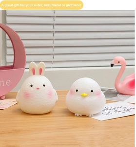 Cute rabbit and chick LED night lights with soft matte texture on wooden desktop