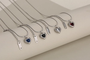 Detail of stainless steel snake chain necklaces featuring heart crystal charms in four colors