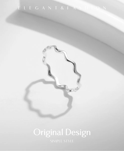 Detail showing elegant silver wave curve ring with polished finish and minimalist style