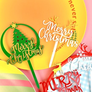 Close-up of double-layered acrylic Christmas cake toppers with reindeer and tree designs