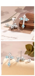 Detail of silver cross stud earrings with blue heart stones and zircon inlay
