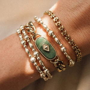 Close-up of vintage gold bracelets set with green African jade and H-link chain