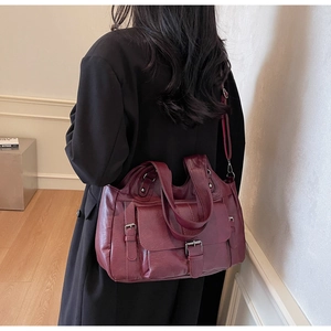 Detail view of burgundy PU leather tote bag with adjustable straps and front flap pockets