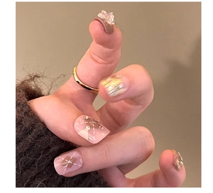 Macro detail of press-on nails with 3D bears, pink plaid patterns and rhinestone accents