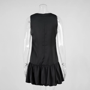 Detail of the back invisible zipper and structured bubble hem on the black mini dress