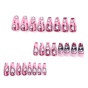 Pink heart press-on nails with dark gothic patterns and rhinestones on white background