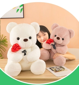 Primer plano de ositos de peluche blancos y rosas con rosas rojas en un hogar cálido