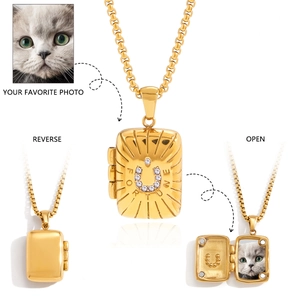 Detailed views of gold horseshoe locket with Fortune engraving and photo slot