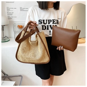Detail of woven straw tote bag with brown leather handles and matching inner pouch