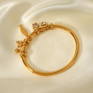 Bracelet jonc ouvert en acier inoxydable doré 18 carats avec charms étoile et poisson
