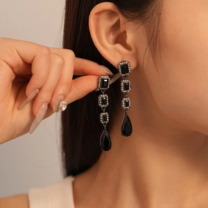 Vue détaillée de boucles d'oreilles noires en forme de goutte avec cristaux carrés étagés