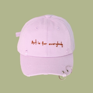 Detail of lavender cotton baseball cap featuring ring accents and Art is for everybody embroidery