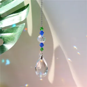 Macro detail of teardrop crystal suncatcher with blue beads reflecting rainbow light