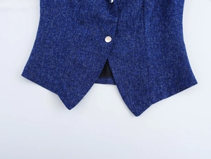 Close-up of blue tweed sleeveless top featuring classic texture and round metal button